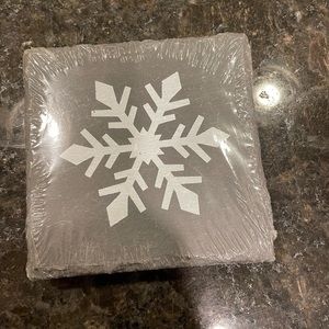 Unopened 4 pack of black ceramic coasters. Snowflake detail on each coaster.